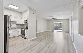 A kitchen with white cabinets and a refrigerator.