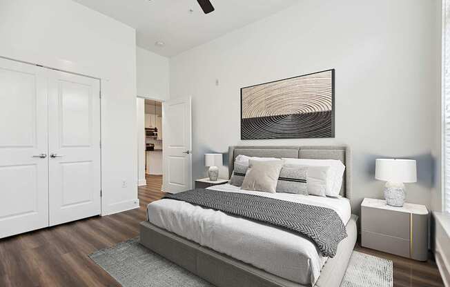 A bedroom with a large bed and a ceiling fan.