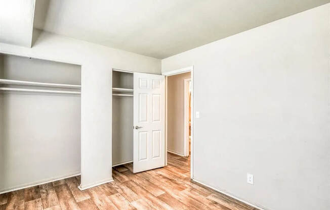 an empty room with white walls and wood floors at Gates of West Bay, Virginia, 23503