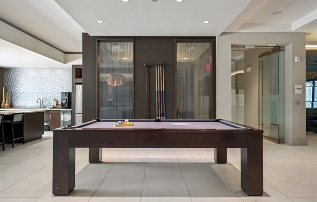 A pool table in a room with a glass door.