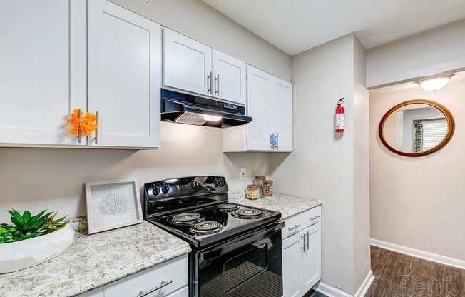 a kitchen with white cabinets and a stove and a microwave