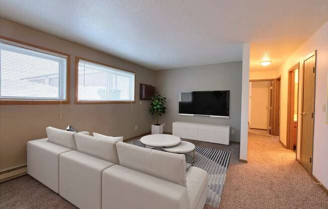 a living room with a white couch and a coffee table. Fargo, ND Kennedy Apartments