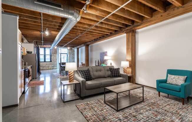 a living room with a couch and a coffee table    and a kitchen