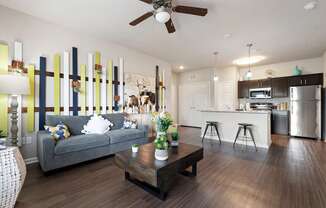 A modern living room with a grey couch and a wooden coffee table.