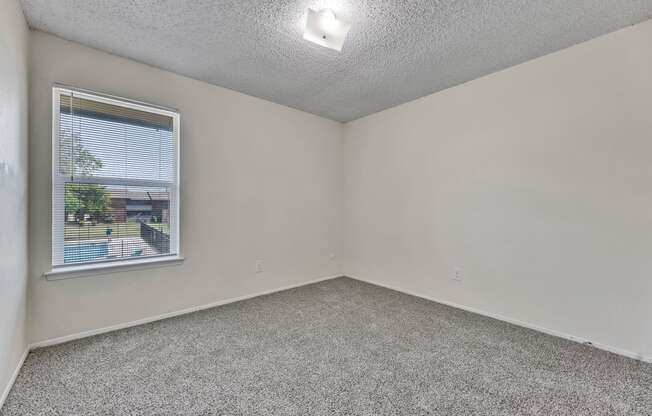 an empty room with carpet and a window