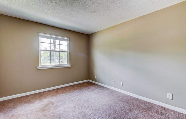 an empty room with carpet and a window