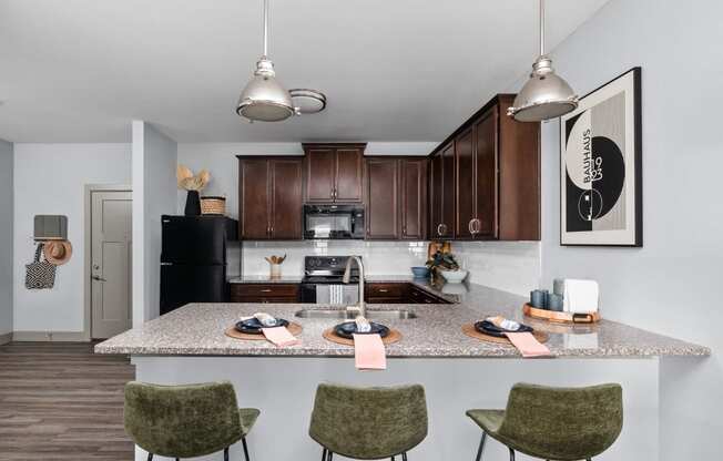 a rendering of a kitchen with an island and stools at the Vue apartments in Indianapolis