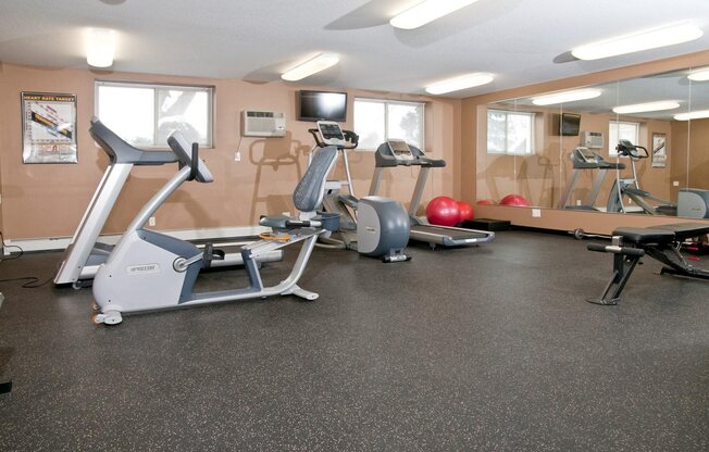 Bass Lake Crossing Fitness Center With Floor To Ceiling Mirrors on Full Wall and Aerobic Equipment