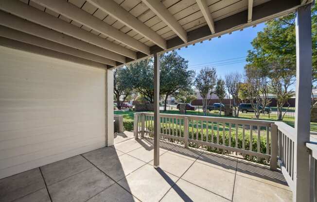 a view to the green area from the covered porch at Woodlands of Plano in Plano, TX