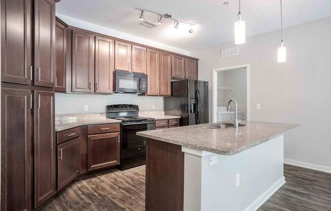 A kitchen with brown cabinets and a granite countertop.