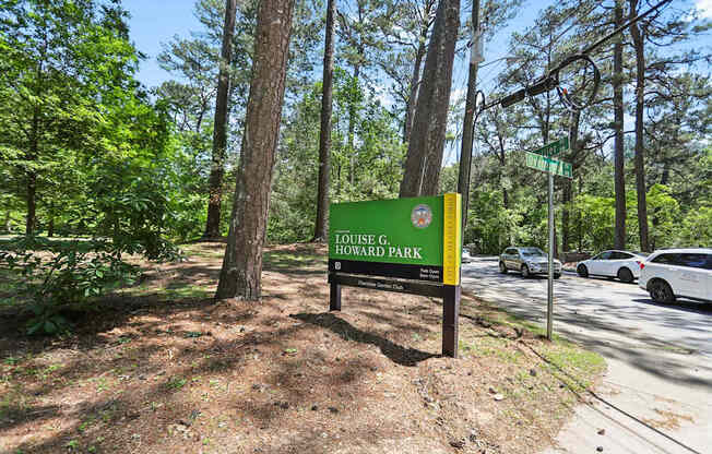 Louise G. Howard Park sign in front of trees.
