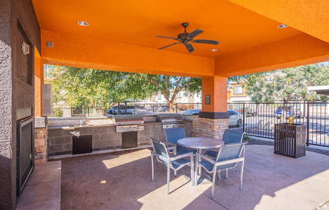 A patio with a table and chairs and a fan.