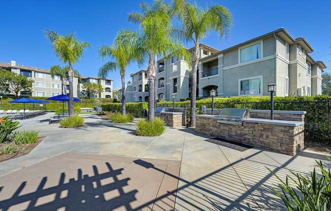 A sunny day at a residential complex with palm trees and a clear blue sky.