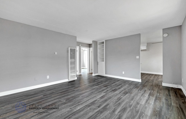 a renovated living room with grey and white walls and wood floors