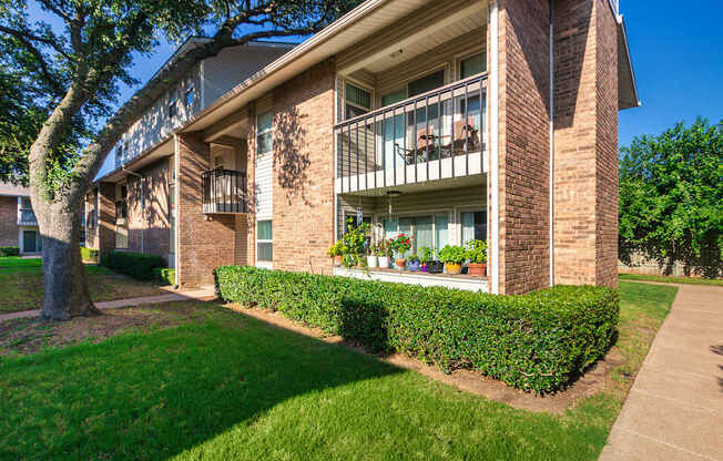 Apartment building exteriors showing patios, balconies and landscaping at Preston Park Apartments in the Far North Dallas neighborhood of Dallas, TX