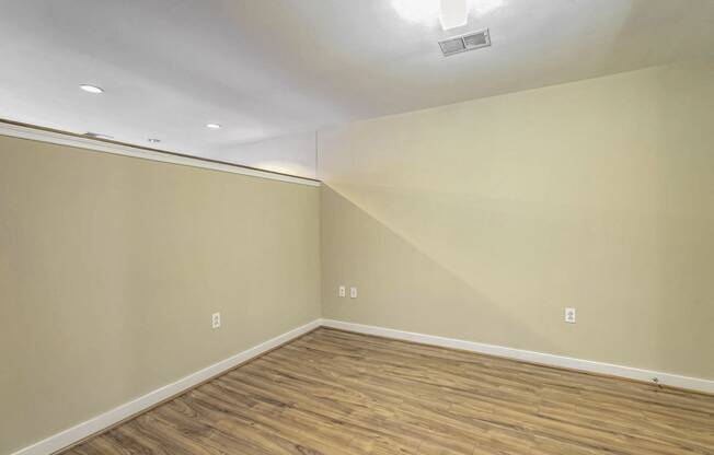 a empty room with wood flooring and white walls