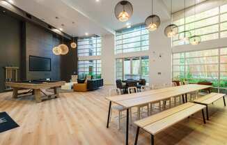 a communal room with tables and chairs and a pool table