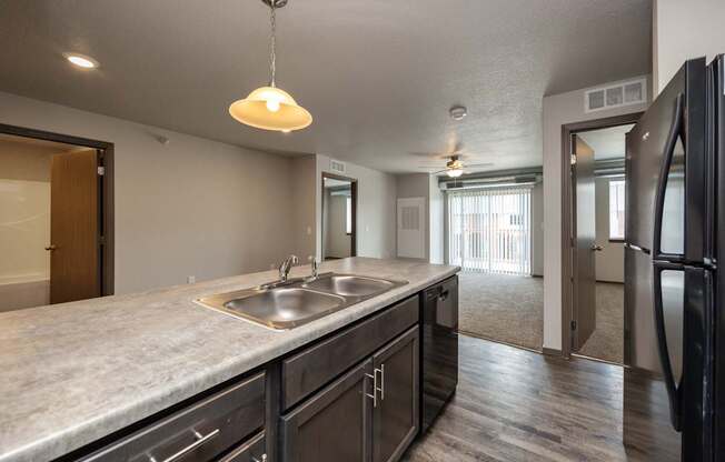 A kitchen with a sink and a refrigerator.