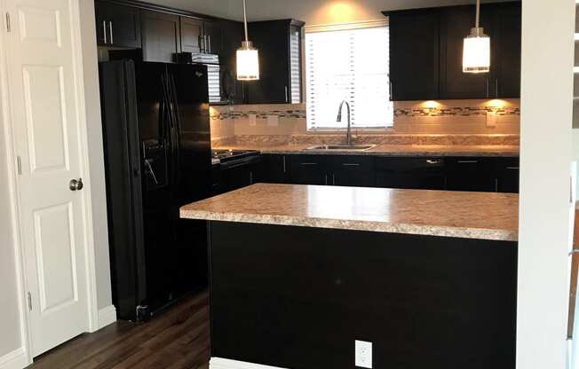 a kitchen with black cabinets and a counter top