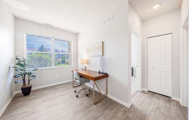 A room with a desk and a chair in it.