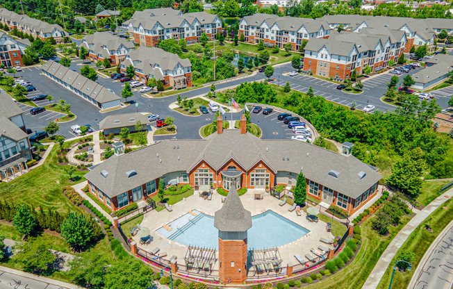 an aerial view of a building with a pool in a parking lot
