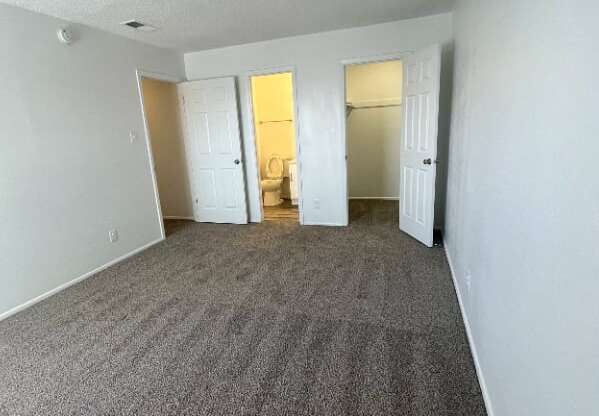 an empty living room with carpeting and white walls