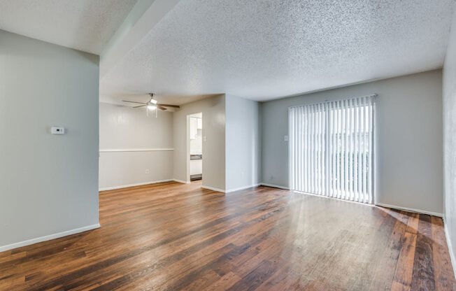 the spacious living room and dining room of an apartment