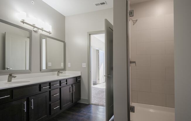 an empty bathroom with two sinks and a shower