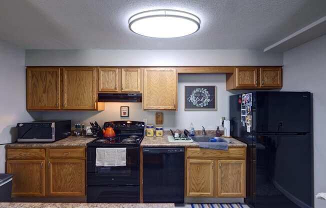 a kitchen with black appliances and wooden cabinets