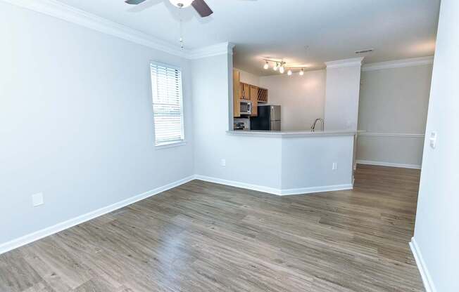 A room with a ceiling fan and wooden flooring.