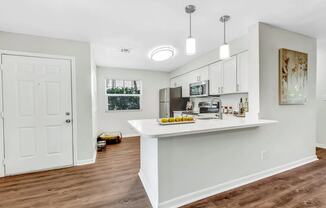 a kitchen with a white counter top and a white door