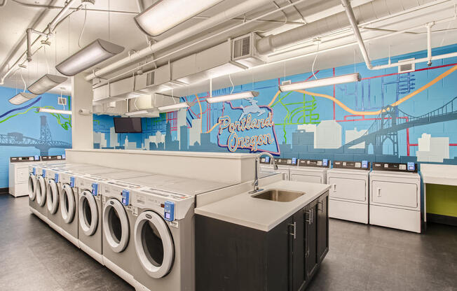 a large laundry room with washers and dryers and a mural on the wall