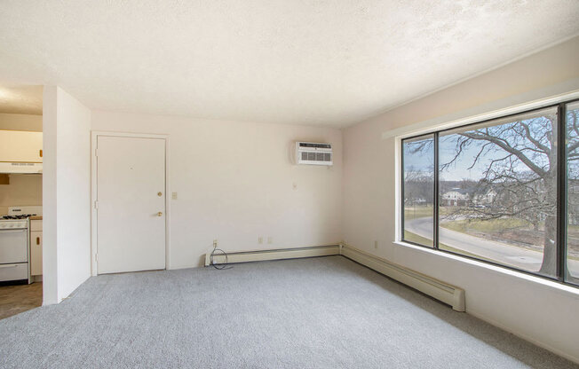 an empty room with a large window and a door