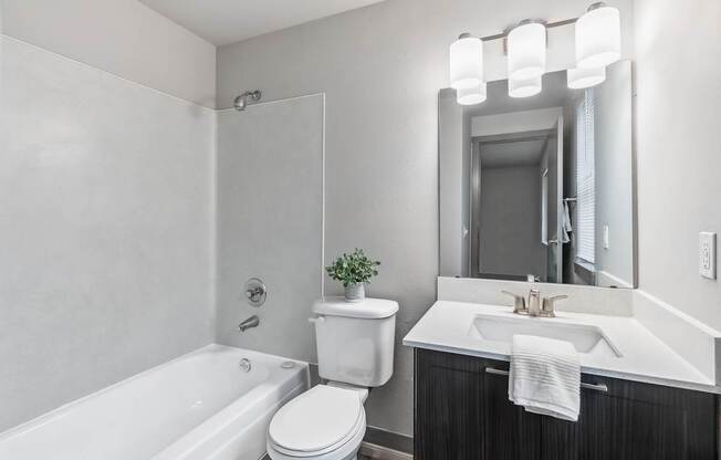 A white toilet sits next to a white sink in a bathroom.