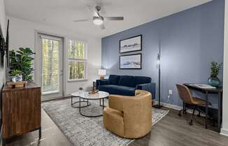 A living room with a blue couch and a brown chair.