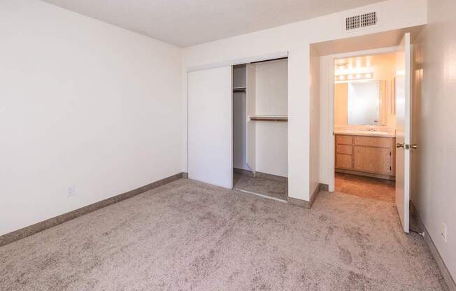 A room with a carpeted floor and a doorway leading to another room.