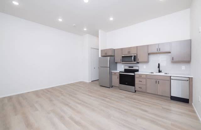 A kitchen with wooden floors and stainless steel appliances.