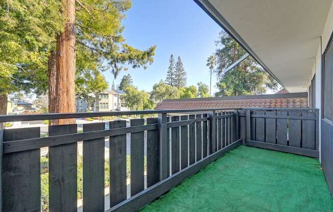 a backyard with a deck and green turf