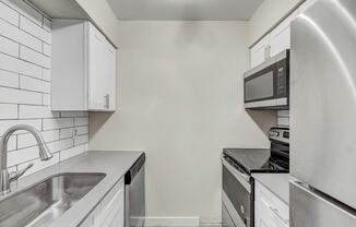 a kitchen with white cabinets and stainless steel appliances