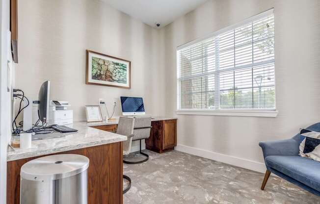 A room with a desk, chair, and a window with blinds.