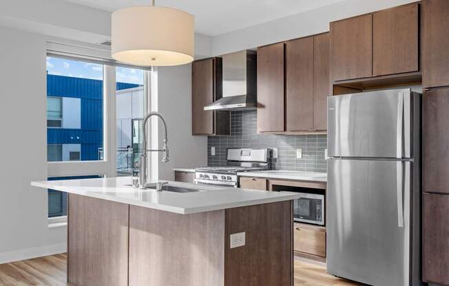 A modern kitchen with a large island and stainless steel appliances.