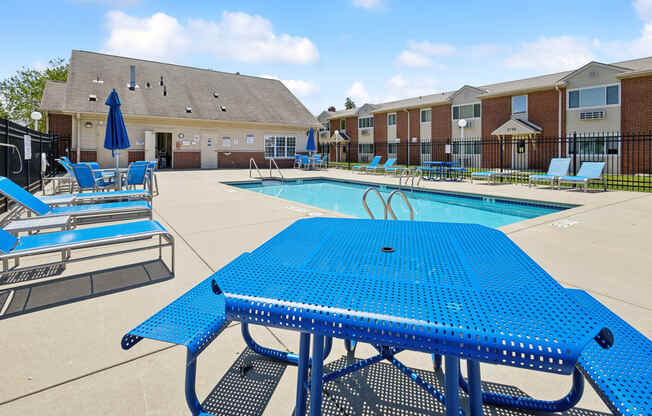 our apartments have a large pool with blue tables and chairs