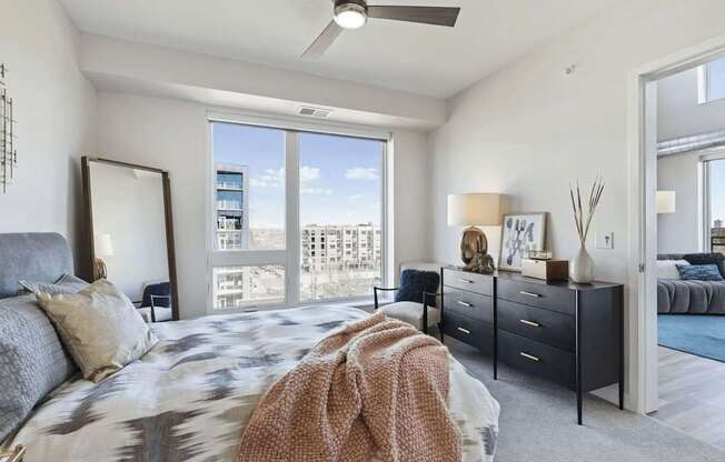 A bedroom with a large bed and a ceiling fan.