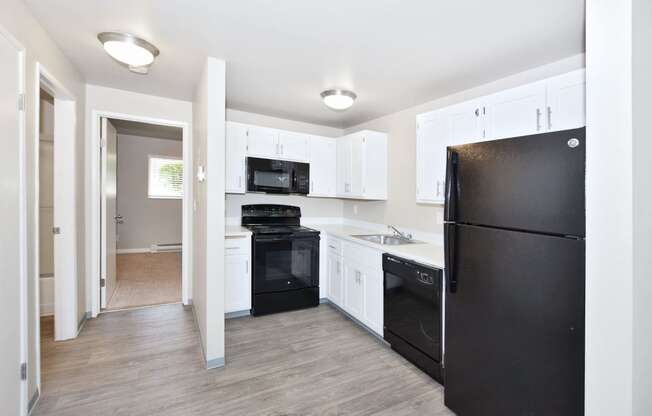 a renovated kitchen with black appliances and white cabinets