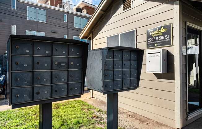 two mailboxes in front of a house with a mail truck