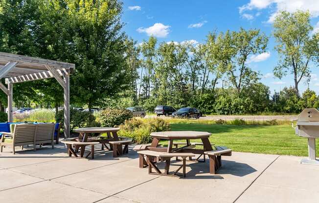 A picnic area with tables and chairs under a pergola.