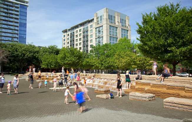 A group of people are walking around a park.