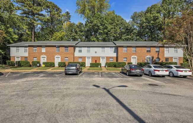 an empty parking lot in front of a brick apartment building