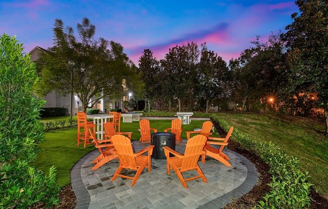 a patio with orange chairs and a fire pit