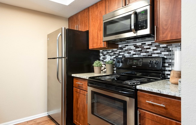 a kitchen with black appliances and a stainless steel refrigerator